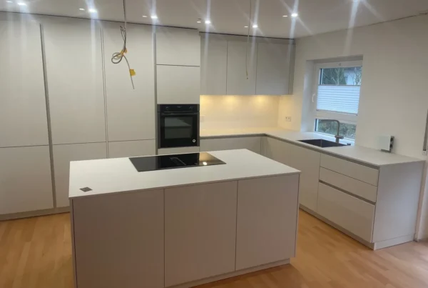 Weiße Küche in Muschelweiß mit Kochinsel und integrierter Architektur – Scholl Küchen Referenz